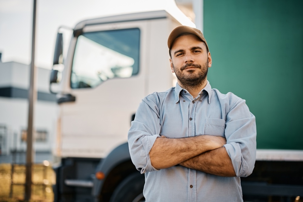 Portrait,Of,Confident,Truck,Driver,On,Parking,Lot,Looking,At
